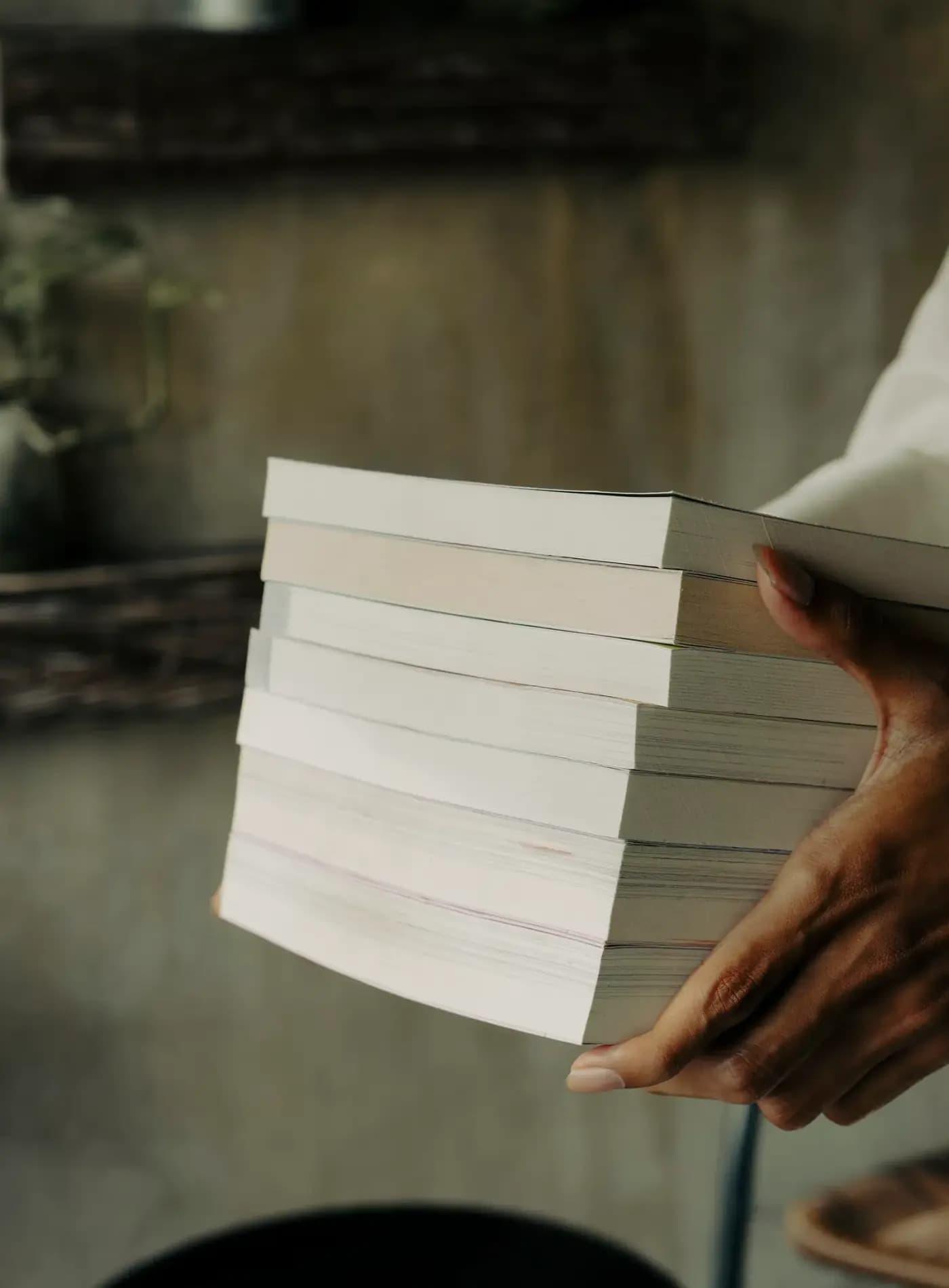 A person holding a stack of books in their hands