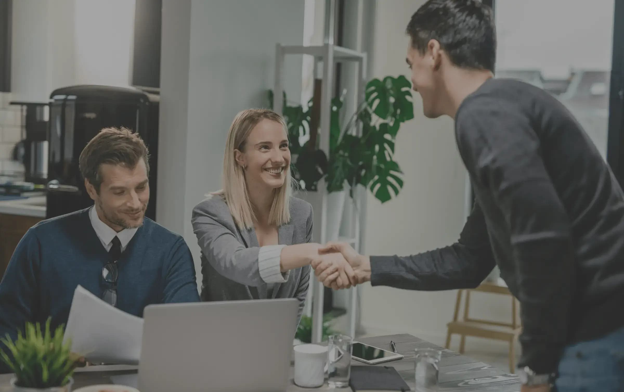 Colleagues shaking hands in an office meeting